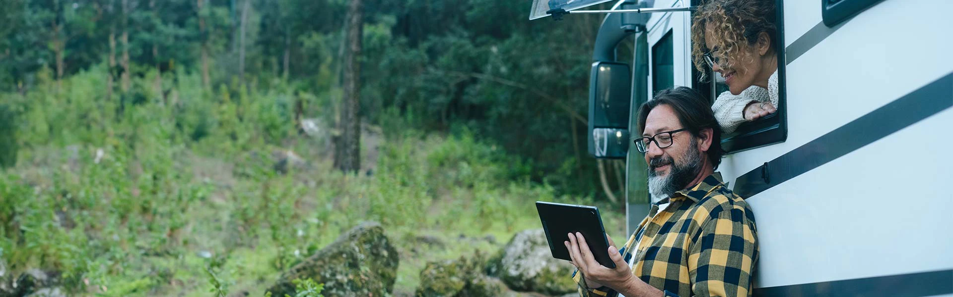 A couple watching a tablet by an RV