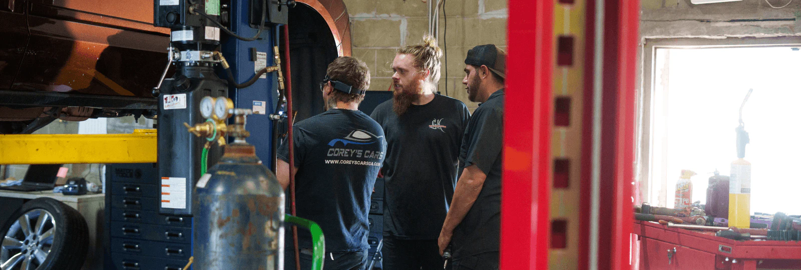 Three mechanic working in a car workshop