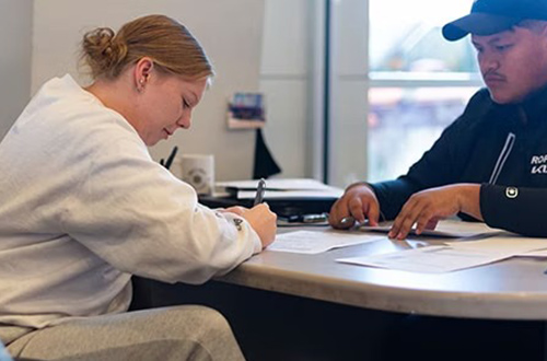 a woman signing a contract in a dealership