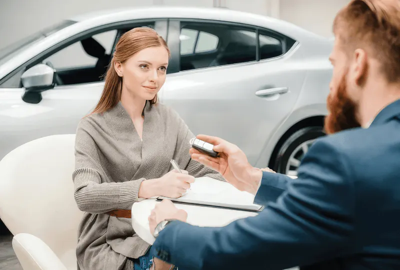two people sitting down in car dealership