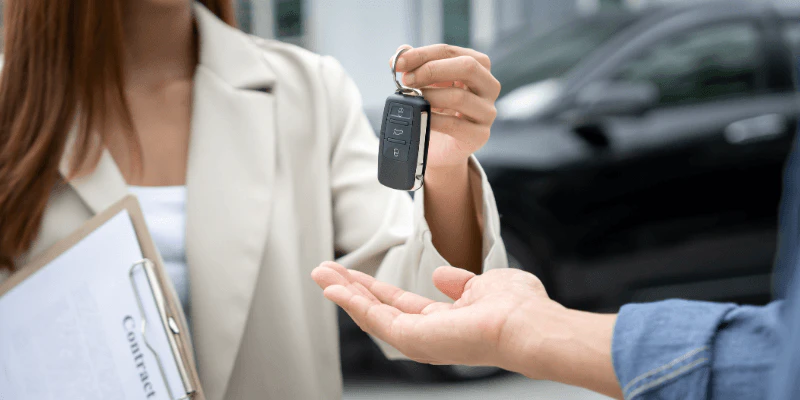 Car salesman holding a car key