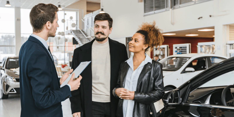 Car salesman having conversation with buyers