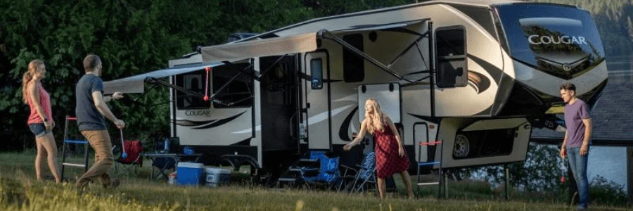 Family setting up tent around RV