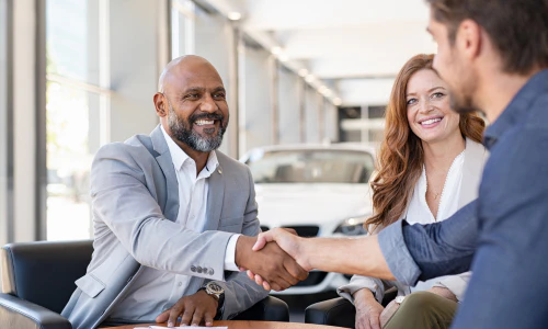 Couple signing up for financing in dealership