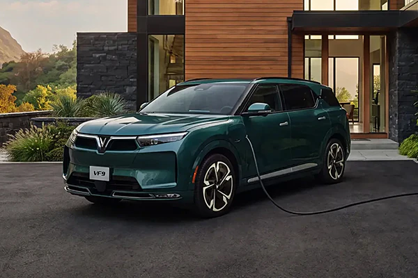VinFast Vf9 plugged in outside beautiful house