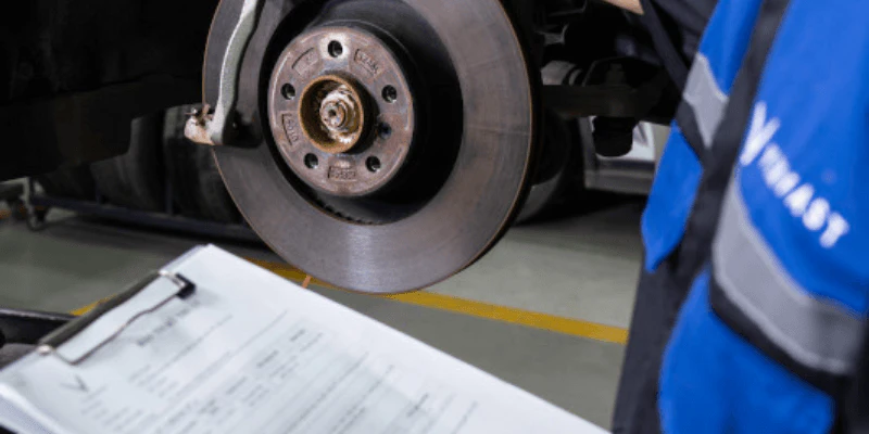 A repairman inspecting a car