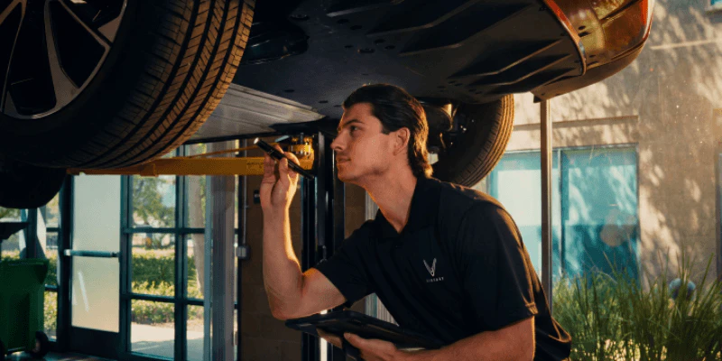 A repairman inspecting a car
