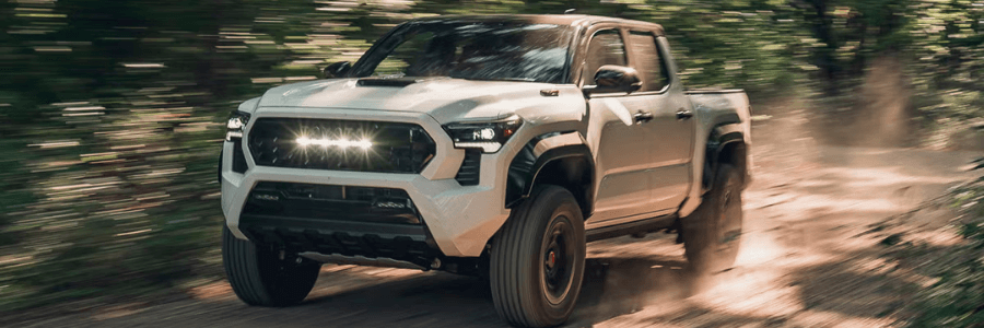 Featured Image 2026 Tacoma in white driving through the forest