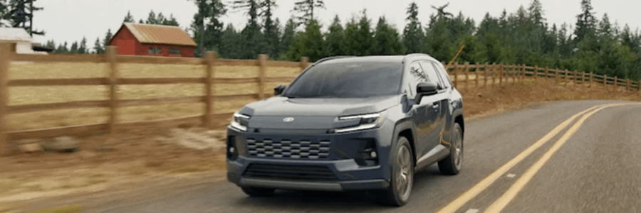 rav4 on a road next to a farm