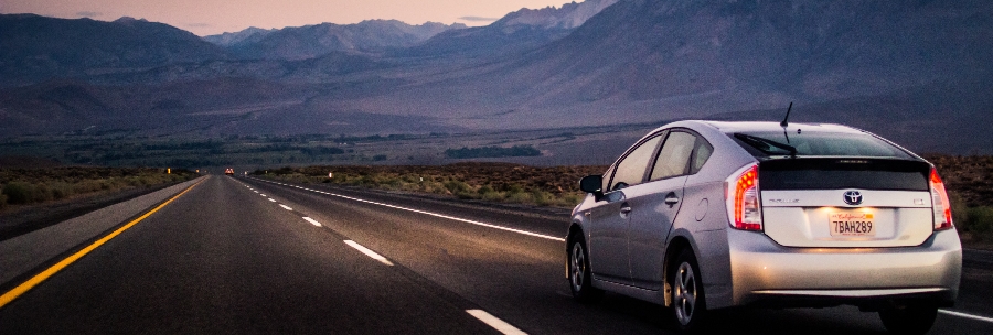 A silver Prius speeds off into the mountains of BC