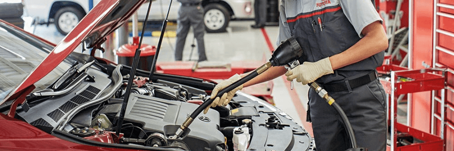 toyota service technician performing oil change