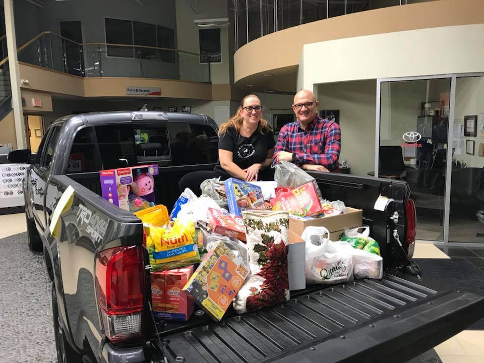 Craig and Jaydee with the Food Bank Toyota Tacoma and a bed full of donations