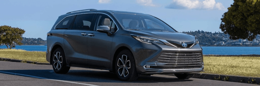toyota sienna on the street against the lake