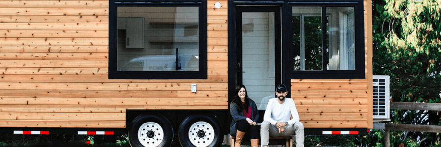 people in front of a tiny home in the woods