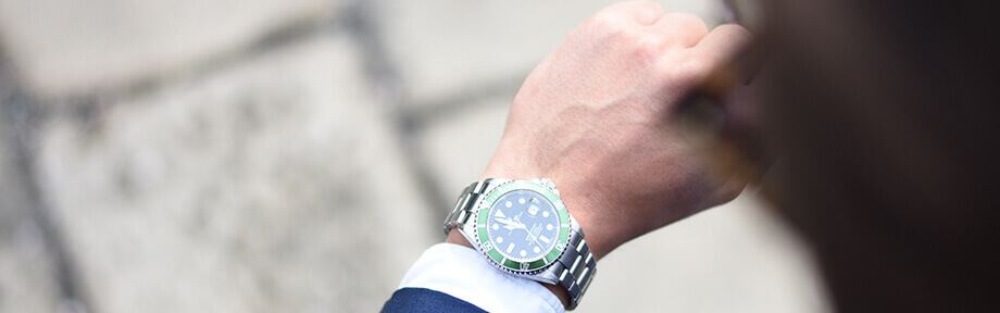 Image of a green Rolex luxury watch on a man's arm