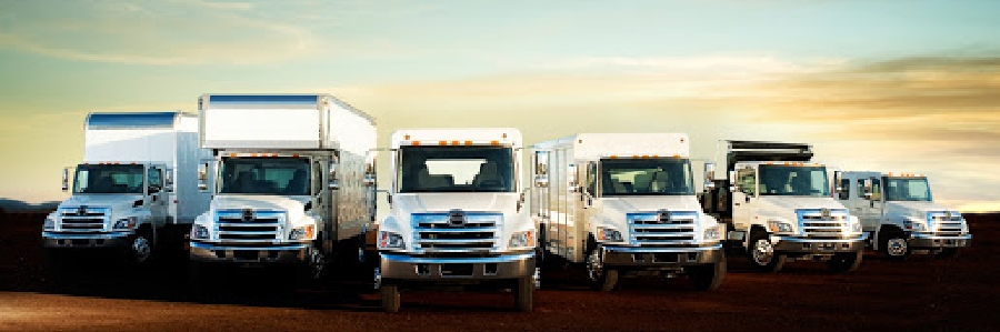 The Hino lineup of delivery trucks sits outside of Someville Hino