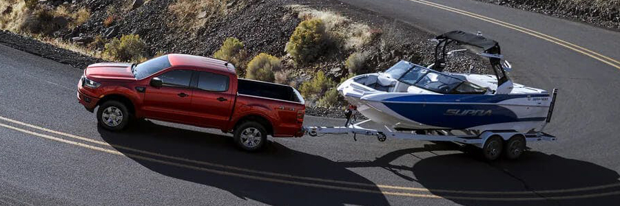 Red Ford Ranger towing a speed boat