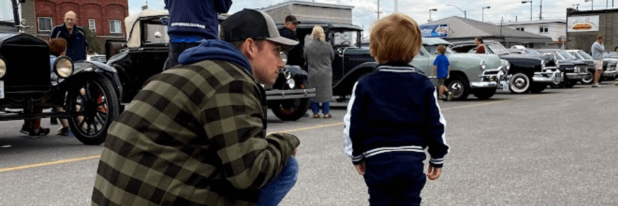Father and son at a vintage Ford car show