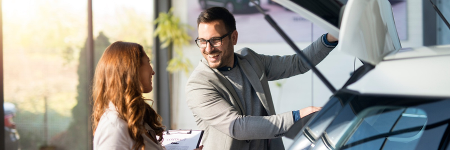 sales rep helping customer at a dealership