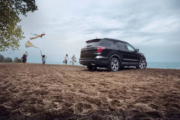 A family plays at a lake in Saskatchewan while their Ford Explorer sits parked near by