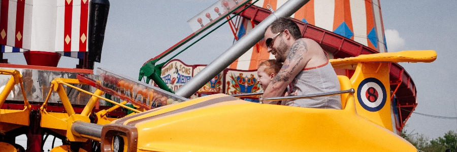 A father and son ride on a yellow fair ride in Saskatchewan