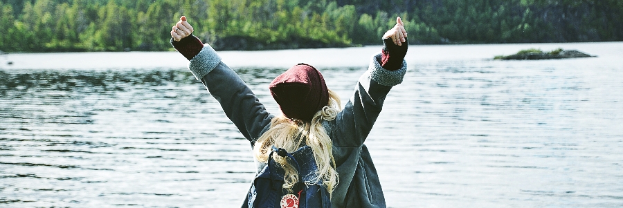 A girl raises her arms near Meadow Lake, SK