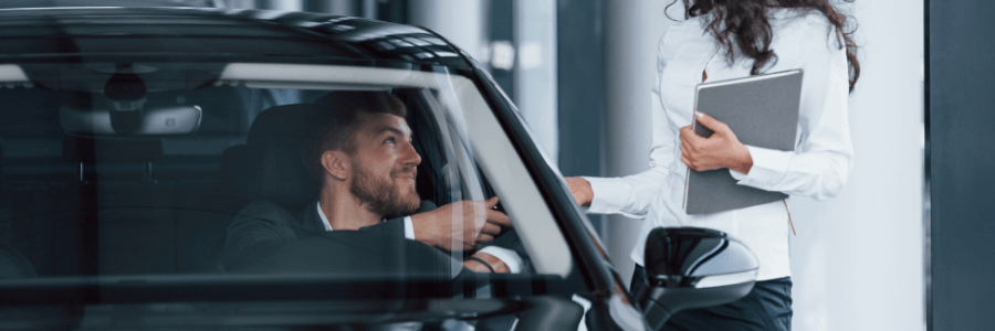 driver in new car at dealership