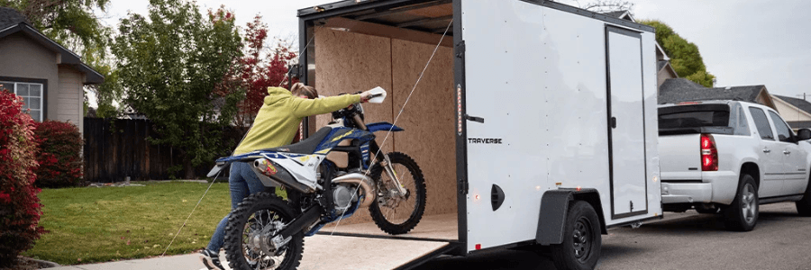 woman loading moto into cargo trailer