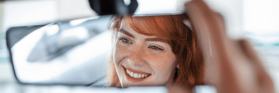 Featured Image young woman driver in rearview mirror