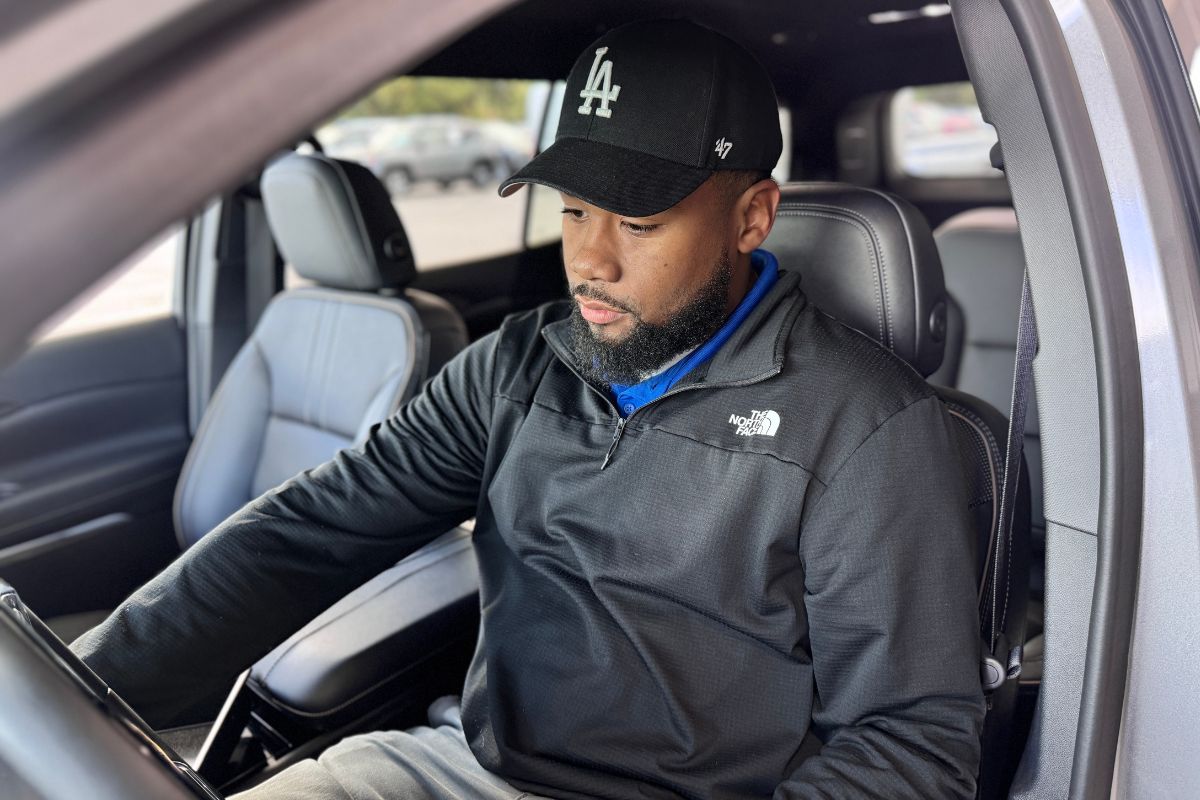 A man sits in the drivers' seat of a Chevrolet SUV at Strosnider Chevrolet looking at the dash's Driver Information Center.
