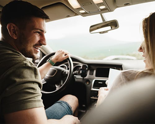 Man and woman driving their new vehicle