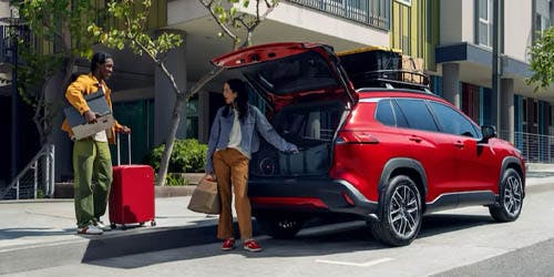a couple loading their luggage in the car trunk