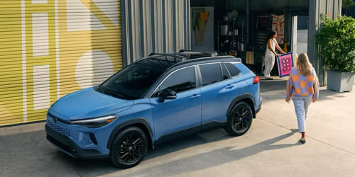 a blue toyota suv parked beside a storage room