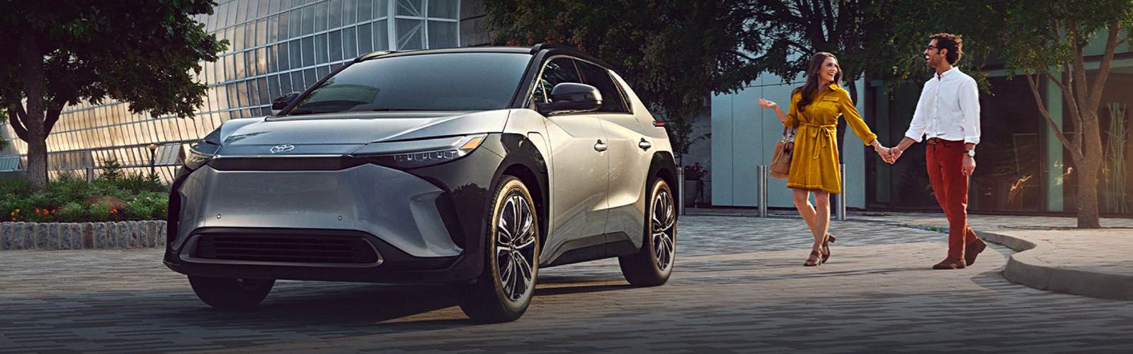 young couple next to Toyota bZ4X