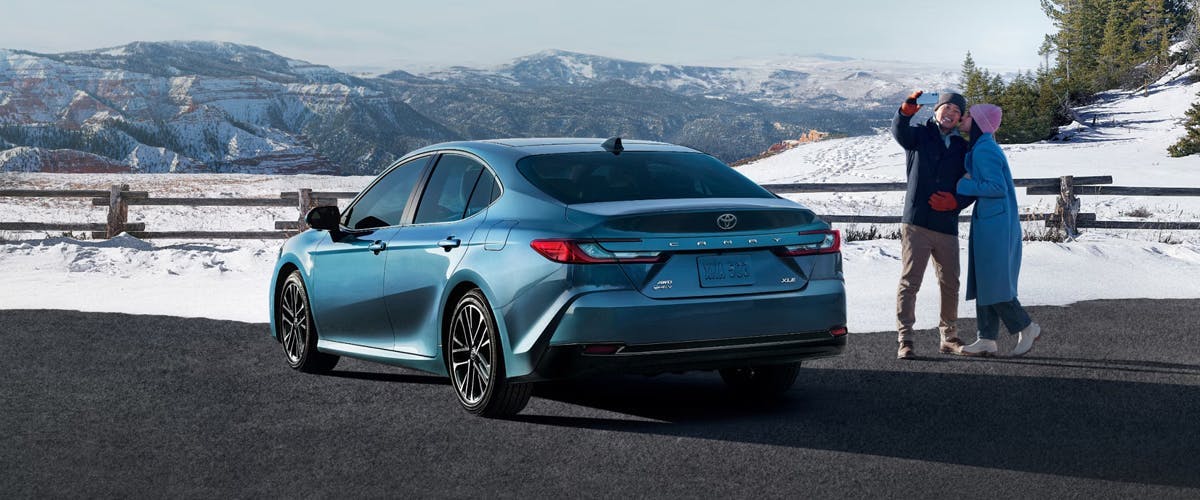 a couple and their camry in winter weather