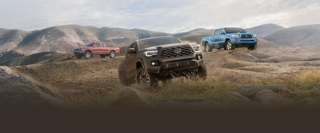 toyota tacoma on bank with toyota in the background