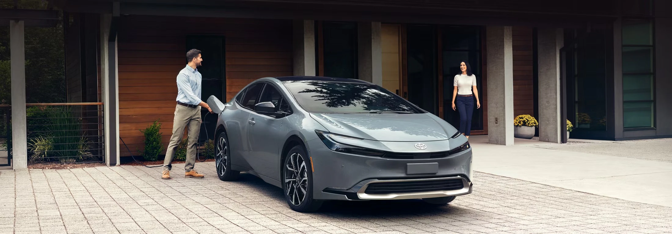 young couple next to Toyota prius plug-in hybrid