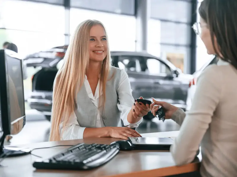 woman receiving car keys from a sales rep
