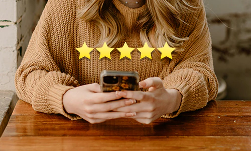 woman leaving a 5 star review on her phone