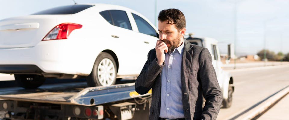 man frustrated with car being towed