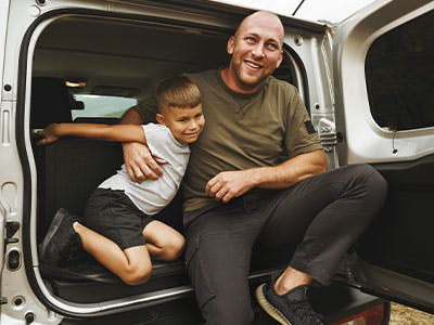 father and son sitting in car rear