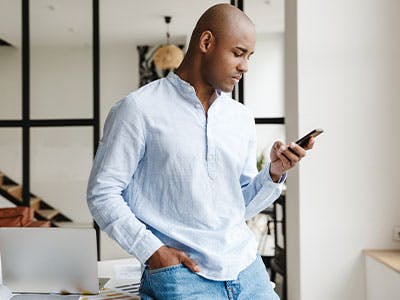 man thinking holding smartphone