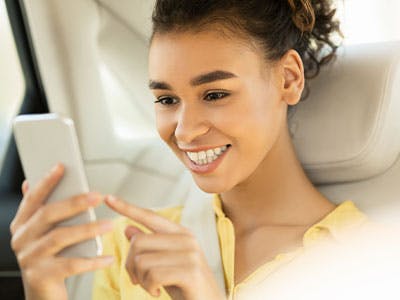 happy woman smiling at smartphone