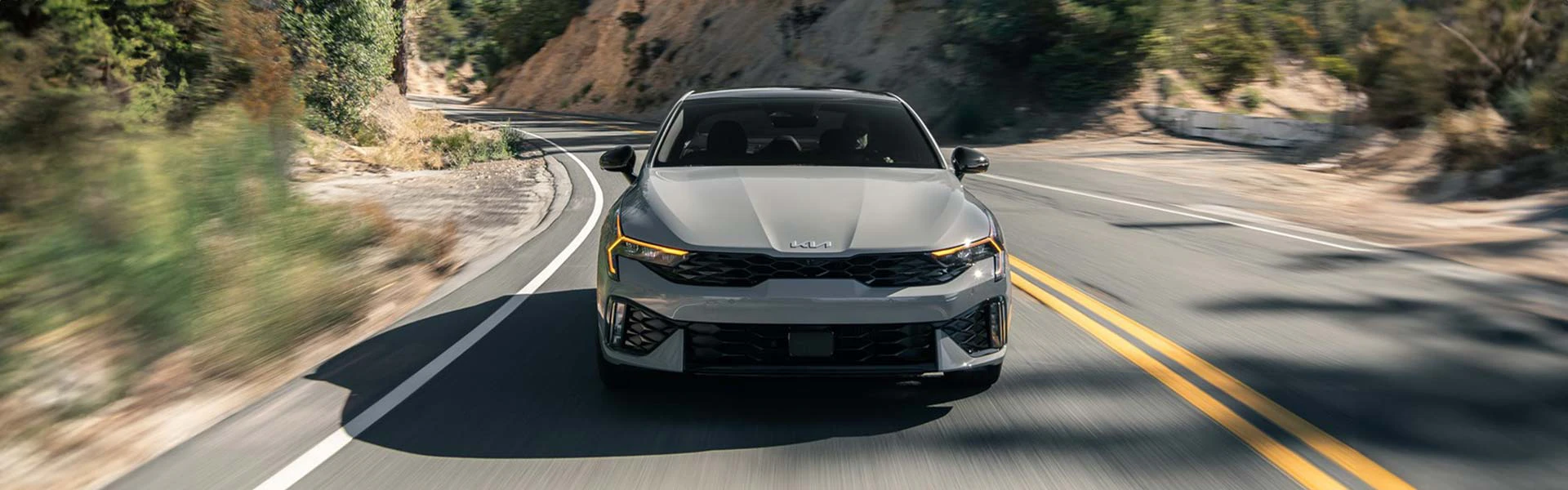 A grey KIA sedan car on the road