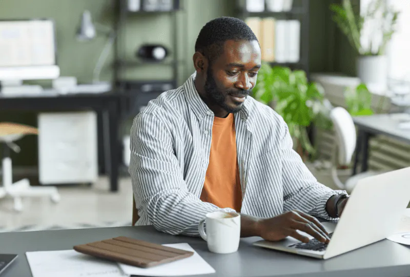 Man sitting and planning his Subaru car financing on his laptop