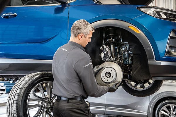 male service technician replacing brakes on a vehicle