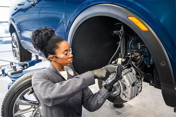 woman service technician performing a brake service