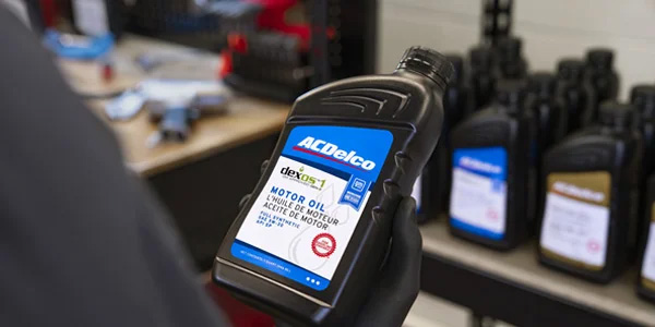 Service tech holding a ACDelco Motor Oil bottle