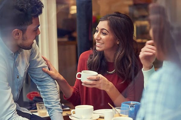 woman laughing with her hand on the shoulder of their partner