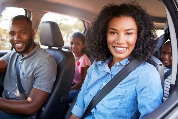 happy family all smiling inside their vehicle